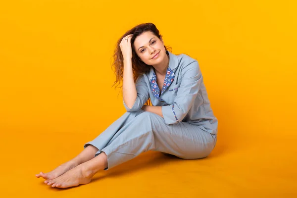 Close up young woman in blue home wear. Isolated on yellow background. Pajama concept. — Stock Photo, Image