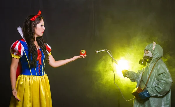 Frau im Märchenkleid, einen Apfel mit Strahlungssymbol in der Hand. Umweltprobleme, radioaktive Katastrophe als Gefahr für die Natur. — Stockfoto