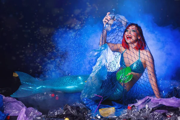 Ocean plastic pollution. Mermaid have fun in water with plastic garbage. Stop plastic pollution. Fairy tale and reality concept.