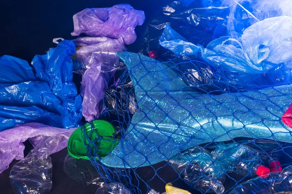 Ocean plastic pollution. Close-up of mermaid swimming in water with plastic garbage. Stop plastic pollution. Fairy tale and reality concept.