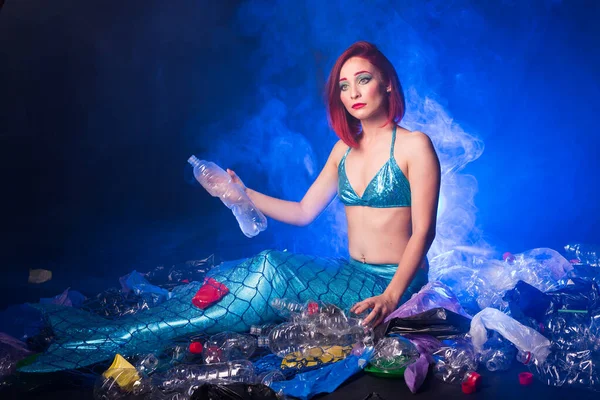 悲伤的童话美人鱼在污染的海洋。塑料垃圾和水里的垃圾。环境问题、塑料袋和瓶子污染珊瑚礁. — 图库照片