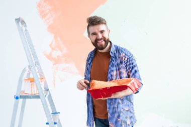 Yeni evin içini boyayan adam. Dekorasyon, yenileme, apartman onarımı ve ferahlatıcı konsept.