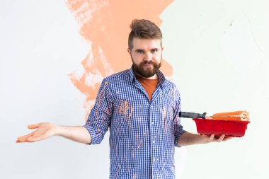 Üzgün adam evin içinde paten yapmakla karıştırılmış. Dekorasyon, yenileme, apartman onarımı ve ferahlatıcı konsept.