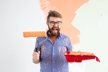 Evin içini boyayan komik adam. Yenileme, onarım ve yeniden dekorasyon konsepti.