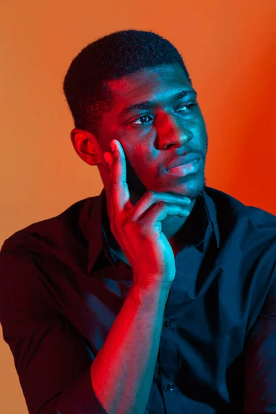 Κοντινό πορτραίτο ενός νεαρού Αφροαμερικανού σε φόντο πορτοκαλί νέον στούντιο. — Φωτογραφία Αρχείου
