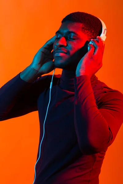 Νεον πορτρέτο του νεαρού Αφρικανού άνδρα που ακούει μουσική με ακουστικά. — Φωτογραφία Αρχείου