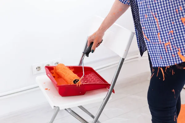 Renovatie, herinrichting en reparatie concept - close-up vrouw van middelbare leeftijd schilderen muur in nieuw huis. — Stockfoto