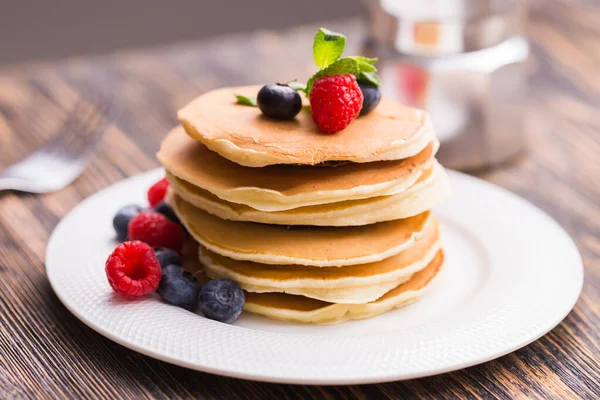 Close-up deliciosas panquecas com mirtilos frescos e framboesas . — Fotografia de Stock