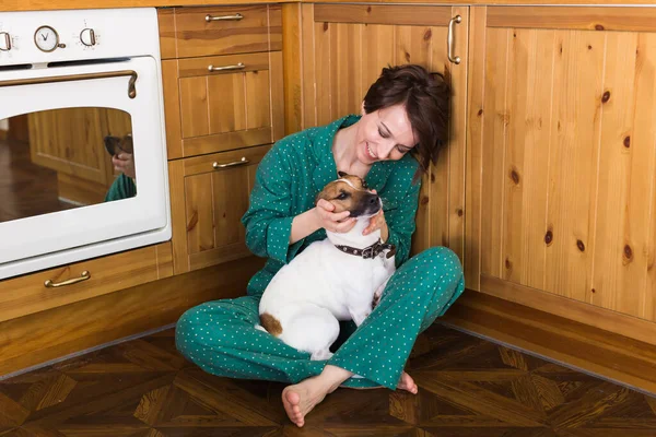 Jeune belle femme à la maison avec son chien mignon. Quarantaine, isolement, monde pandémique de coronavirus. Reste à la maison. . — Photo
