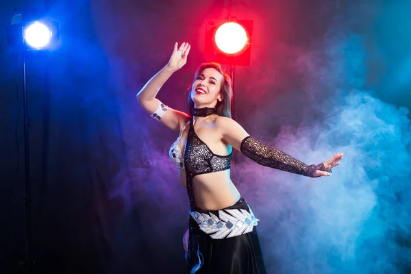 Young woman belly dancer in exotic dress with gold, dancing tribal fusion dance in studio. — Stock Photo, Image