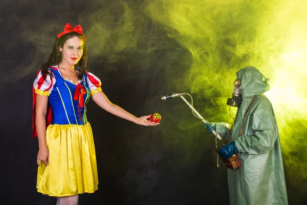 妖精の物語のドレスを身に着けている女性放射線のシンボルとリンゴを保持。環境問題、自然災害としての放射線災害. — ストック写真