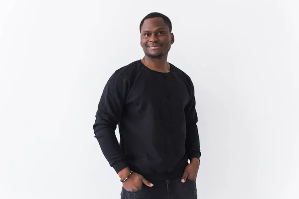 Street fashion concept - Studio shot van jonge knappe Afrikaanse man dragen sweatshirt tegen witte achtergrond. — Stockfoto
