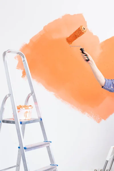 Primo piano della donna di mezza età che dipinge il muro nel suo nuovo appartamento. Concetto di ristrutturazione, ridecorazione e riparazione . — Foto Stock