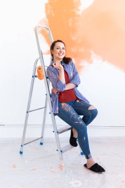 Apartmanda tamirat var. Mutlu kadın duvarı boyuyor..