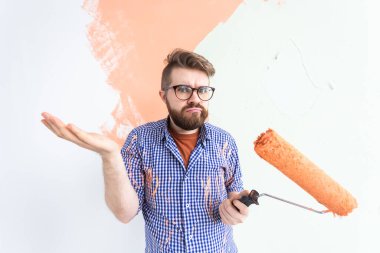 Apartmanda tamirat var. Kafası karışmış komik bir adam boyayla duvarı boyuyor..