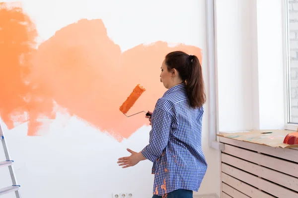 Renovace, rekonstrukce a opravy koncepce - Tancování legrační žena malování stěn v novém domě. — Stock fotografie