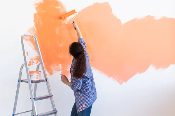 Ballando donna divertente pittura muro interno della nuova casa. Ristrutturazione, ristrutturazione, riparazione di appartamenti e concetto di ristoro . — Foto Stock