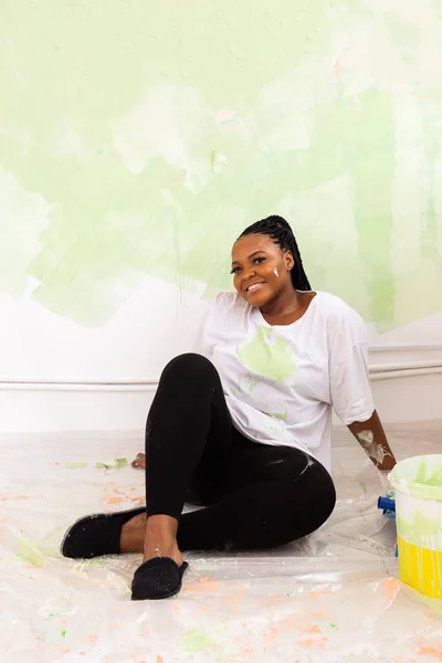 Apartmanda tamirat var. Mutlu genç bir kadın duvarı boyuyor.. — Stok fotoğraf
