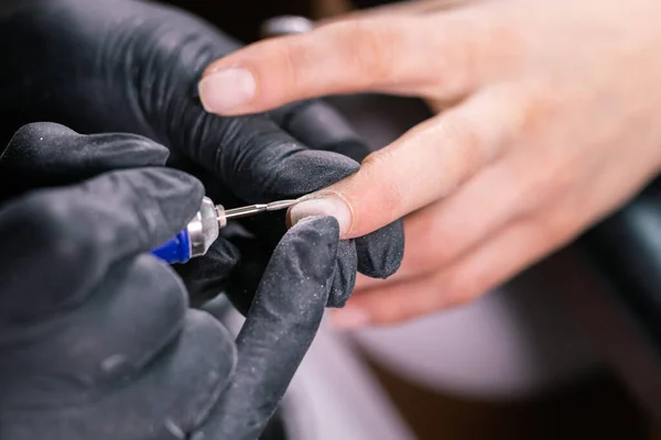 Donna usano lima elettrica trapano nel salone di bellezza. Processo di manicure delle unghie in dettaglio. Semipermanente concetto close-up. — Foto Stock