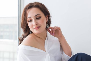 Küpeli zarif bir kadın, yakın portre. Aksesuarlar, mücevherler ve bijouterie konsepti.