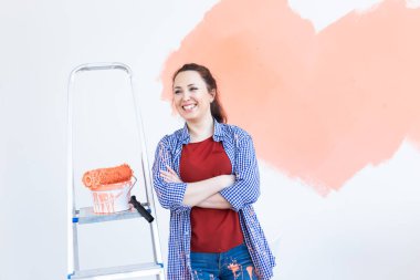 Yeni dairesinde duvar boyayan güzel bir kadın. Yenileme ve dekorasyon konsepti.