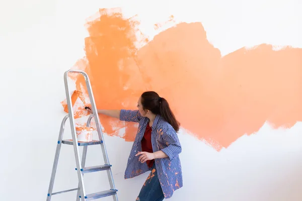 Dansa rolig kvinna med målning roller inomhus. Renovering, renovering, lägenhetsreparation och förfriskningar. — Stockfoto