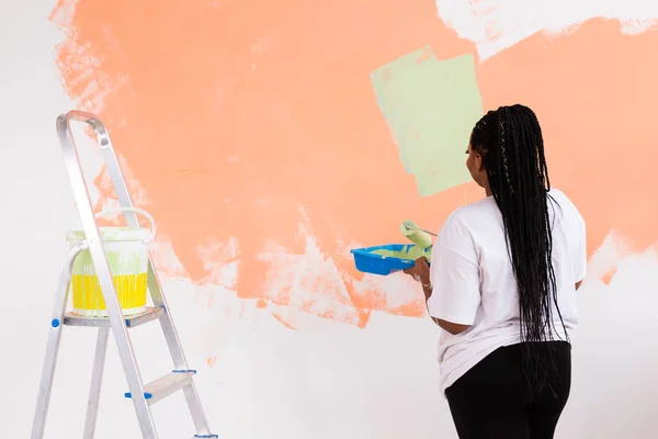 Apartman boyayan Afro-Amerikan kadın. Yenileme, onarım ve yeniden dekorasyon konsepti. — Stok fotoğraf