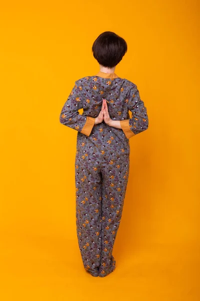 Modeporträt ziemlich coole Mädchen in Pyjama tragen Spaß über bunten gelben Hintergrund. Yoga-Konzept. — Stockfoto