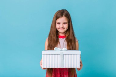 Mutlu çocuk mavi arka planda doğum günü hediyeleri tutuyor. Noel zamanı. Çocukların doğum günü.