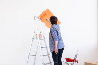 Evin içinde paten yapan orta yaşlı güzel bir kadın. Dekorasyon, yenileme, apartman onarımı ve ferahlatıcı konsept.