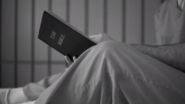 Hombre preso en prisión leyendo la Biblia — Vídeo de stock