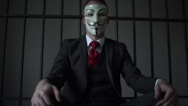 Low angle view of Anonymous hacker in prison — Stock Video