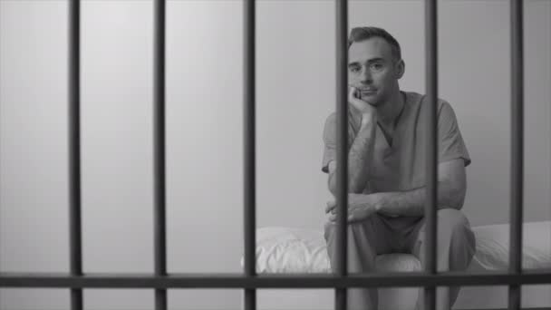 Заключенный, сидящий в тюрьме — стоковое видео