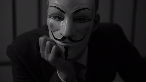 Hacker anônimo descansando seu queixo em sua mão na prisão (Versão B / W ) — Vídeo de Stock