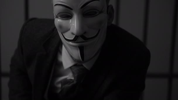Anonymous hacker man stares into camera in prison (B/W Version) — Stock Video