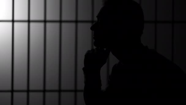 Silhouette of man in jail — Stock Video