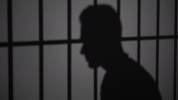 Silhouette of man in jail — Stock Video