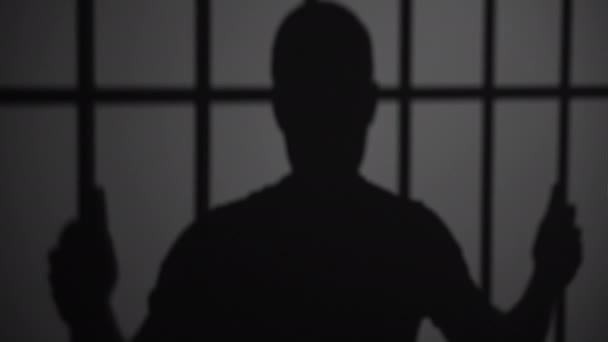 Silhouette of man in jail — Stock Video