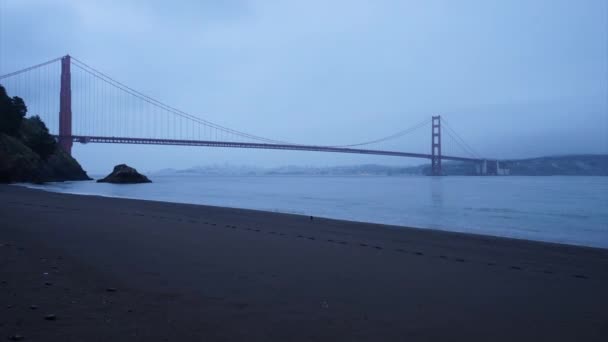 Vista de lapso de tiempo de la playa siniestra por Golden gate Bridge — Vídeo de stock