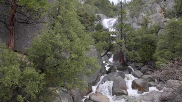 Um rio de nascente inchado cai sobre rochas em Yosemite — Vídeo de Stock