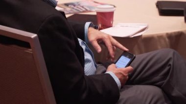 Adam telefon bir konferans sırasında kullanır.