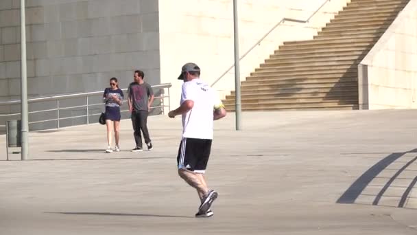 Man jogs by the Bilbao Guggenheim — Stock Video