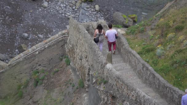 Bezoekers lopen de stappen van San Juan de Gaztelugatxe — Stockvideo