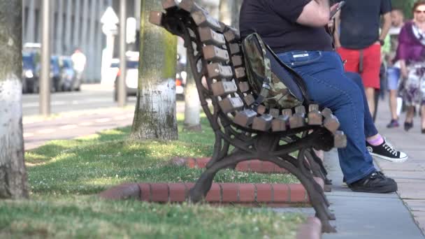 Turista obeso se sienta en un banco de parque en España — Vídeos de Stock