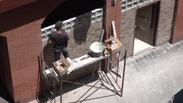 Maçon ouvrier de la construction se tient sur échafaudage — Video