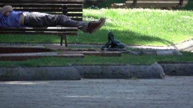 Bir adam bir fountian bir bankta uyur.