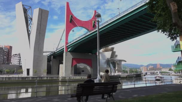 Man sitter på en bänk nära La Salve Bridge i Bilbao, Spanien — Stockvideo