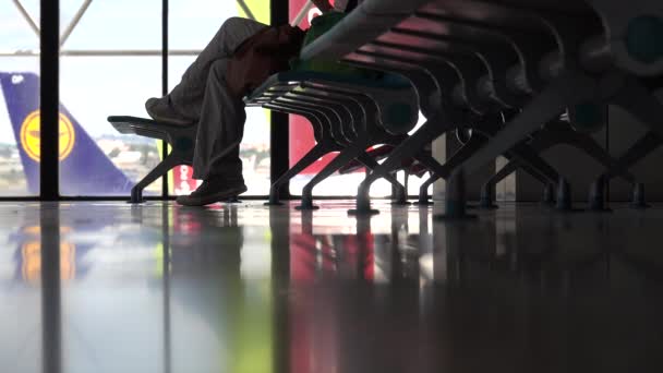 Un viajero se sienta en un aeropuerto esperando tomar un vuelo — Vídeos de Stock