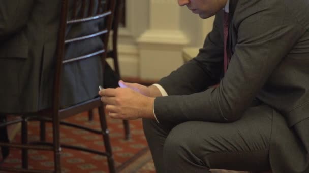 Člověk používá svůj telefon během obchodní události — Stock video