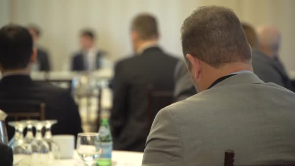 Un uomo vestito di grigio assiste ad una conferenza — Video Stock